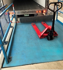 Loading dock scissors lift used to level the surface needed for loading and unloading trucks