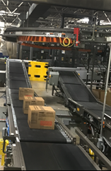 Two incline Motorized Driven Roller (MDR) zone to zone accumulation conveyors which move product from one warehouse ergonomic worker’s elevation to the palletizer’s infeed elevation.