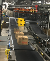 Boxes are being transported on zero pressure accumulation zoned conveyors; each individual box will not leave its own zone until the Motorized Driven Roller Conveyor (MDR) zone in front of it is clear of product.